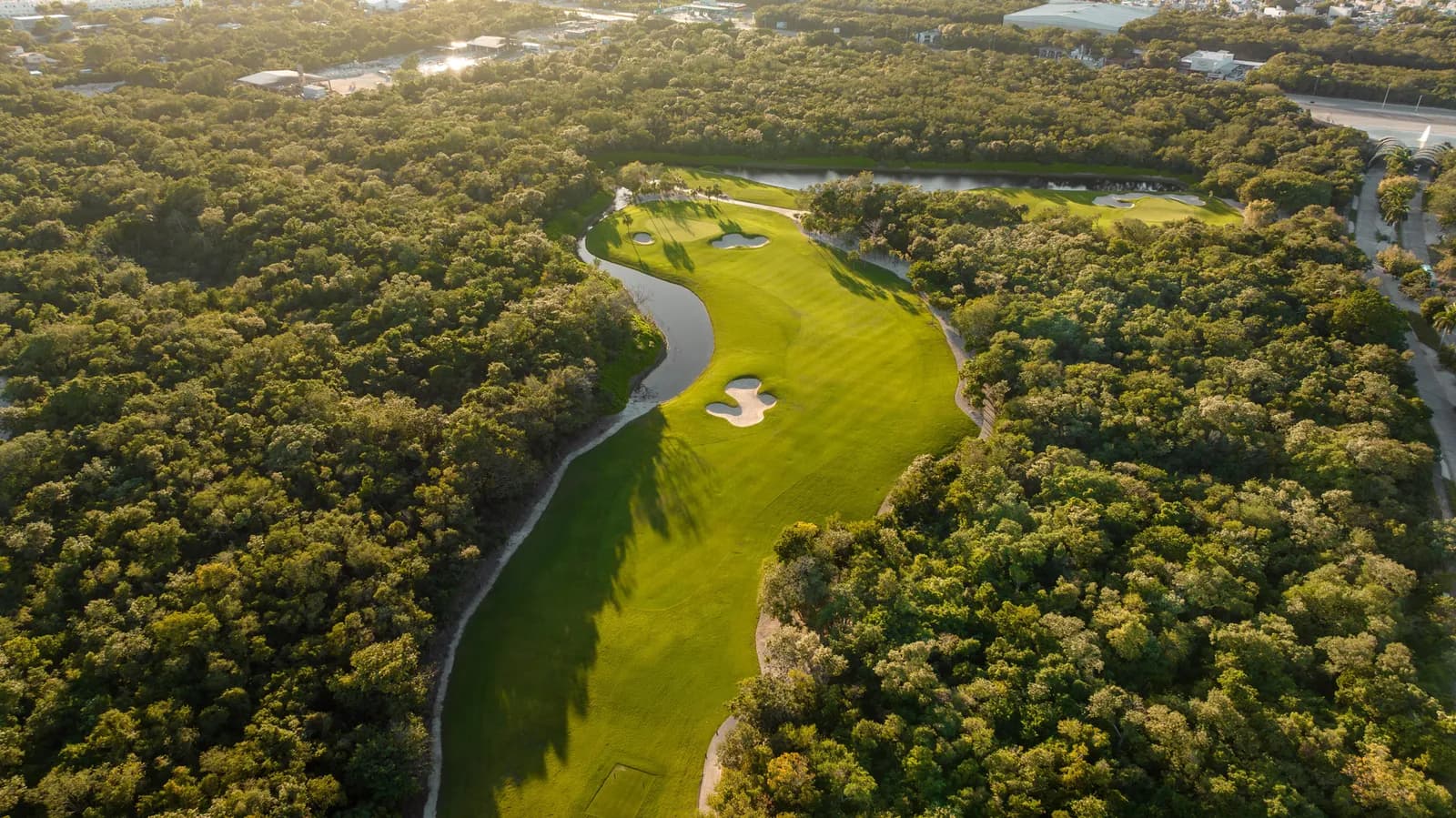 Golden-hour aerial of Gran Coyote's jungle-lined opening fairway