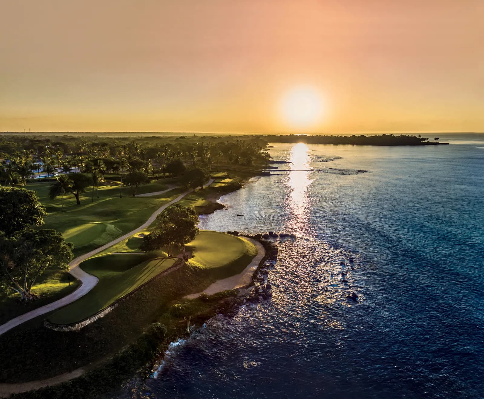 Sunset aerial of Teeth of the Dog's oceanfront holes along the dark Caribbean coast