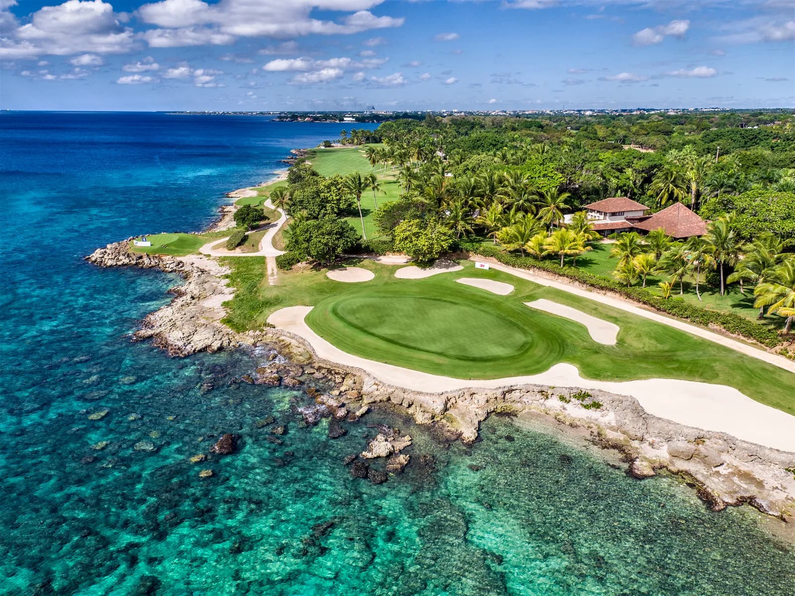 Drone view of a Teeth of the Dog green on a coral point surrounded by turquoise water