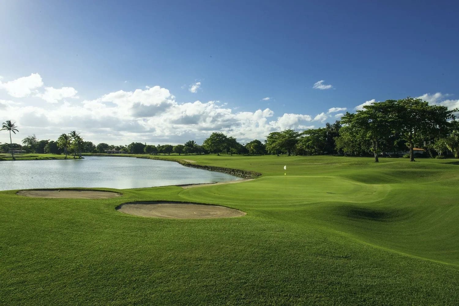 A Links green beside a lake with bunkers in morning light