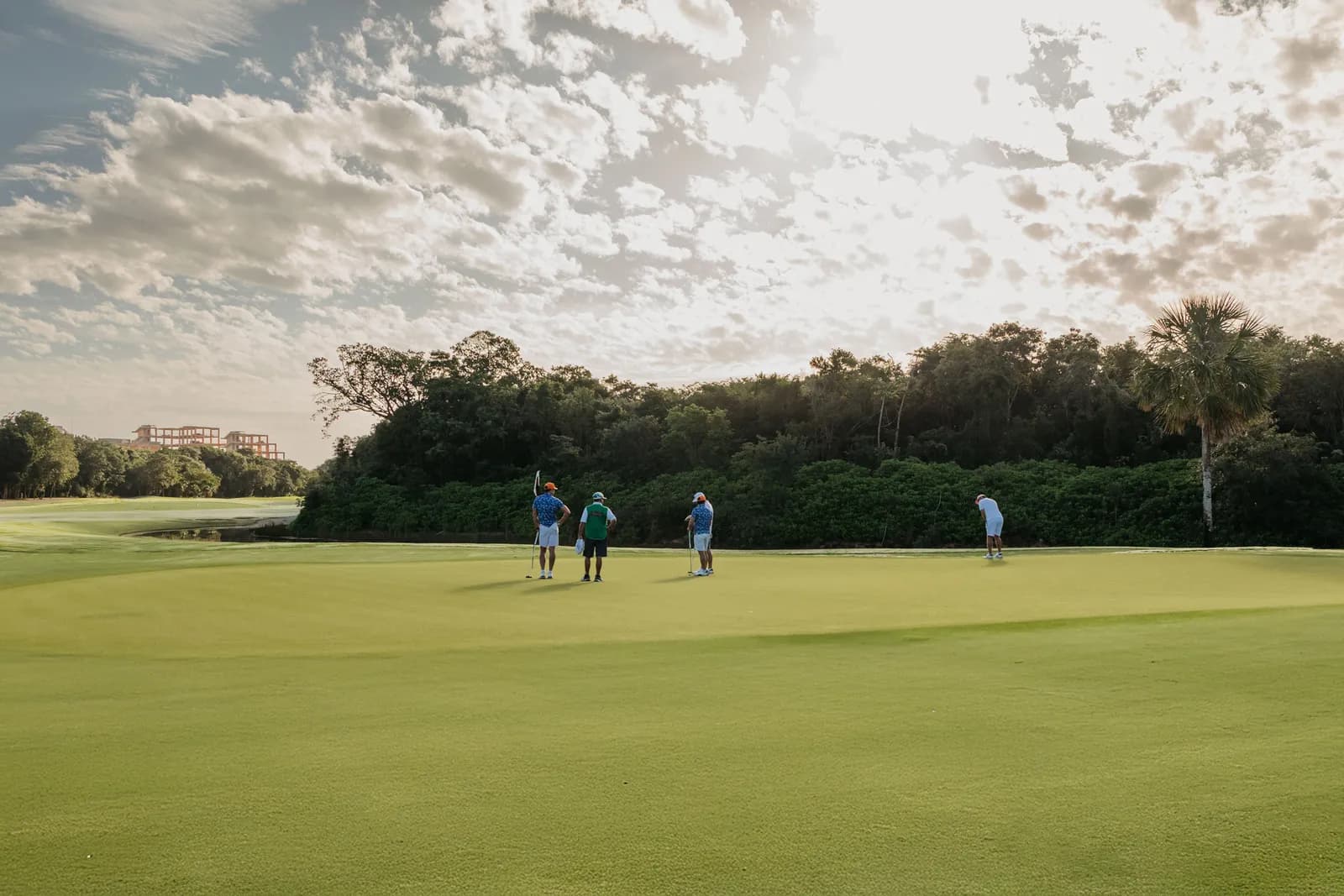Golfers putting on a large green at Gran Coyote Golf