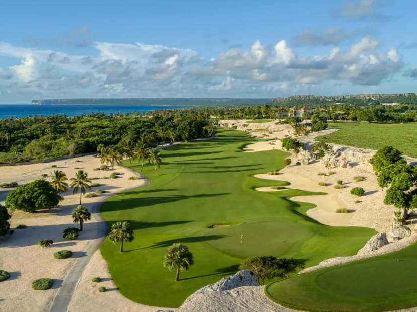 Aerial view of a Punta Espada fairway between white limestone waste areas, running toward the sea cliffs of Cap Cana
