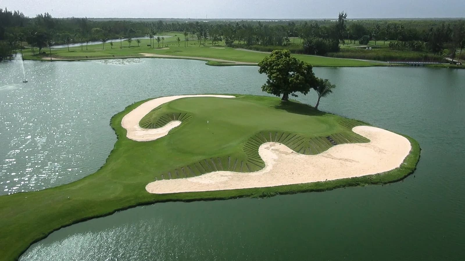 Aerial of a Lakes Barceló island green ringed by slatted timber-faced bunkers and sand