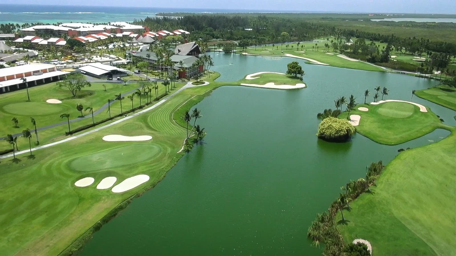 Aerial over The Lakes Barceló with lakes, white bunkers and the Bávaro shoreline beyond