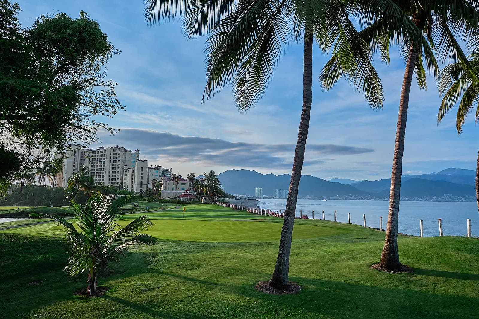Marina Vallarta — a green at the water's edge, the bay on one side and the Sierra Madre across it.