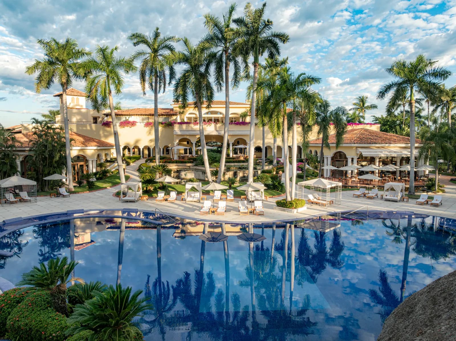 The pool at the heart of the hacienda, ringed by royal palms.