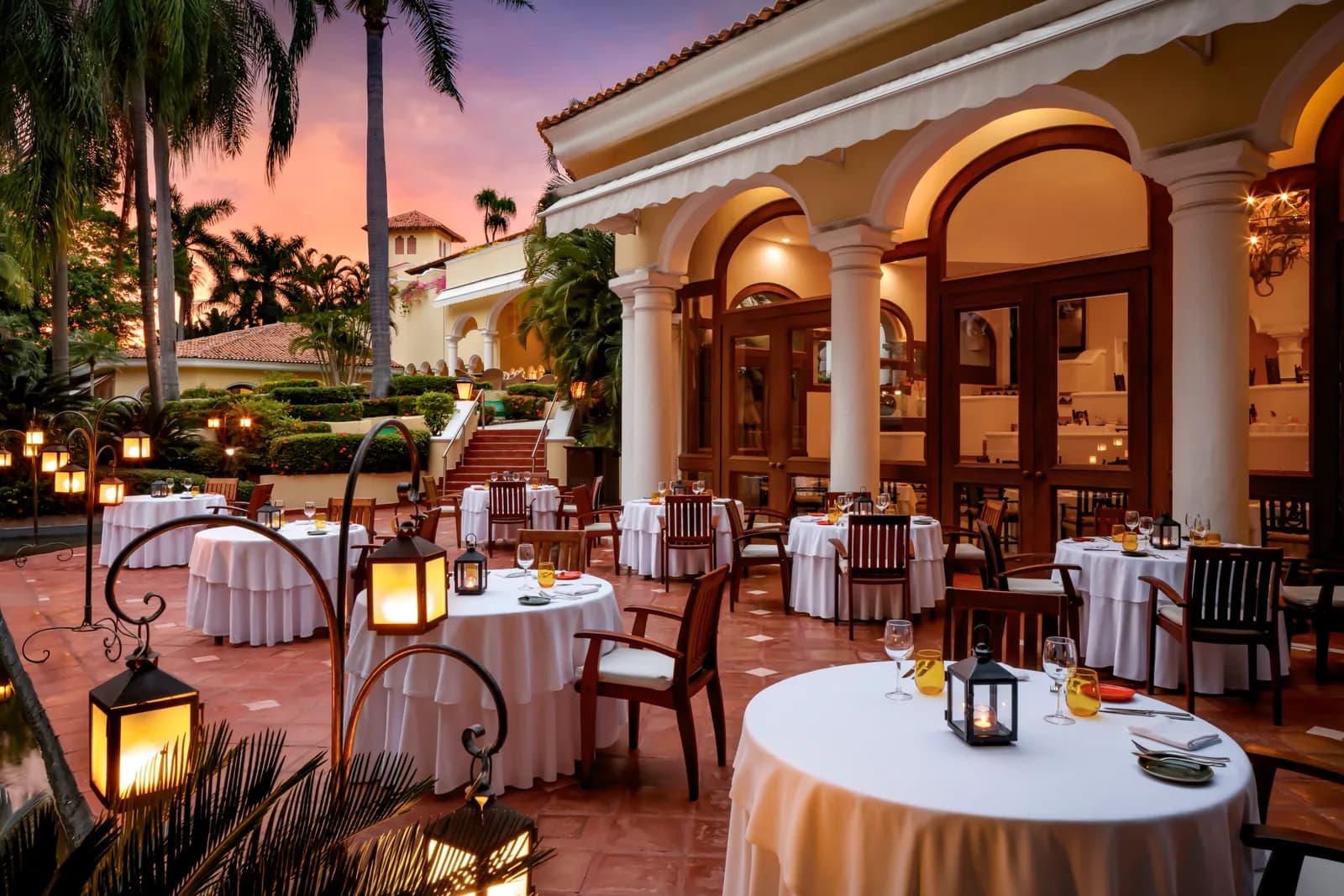 Emiliano at dusk — lanterns, white linen, and a dinner that takes as long as you want it to.